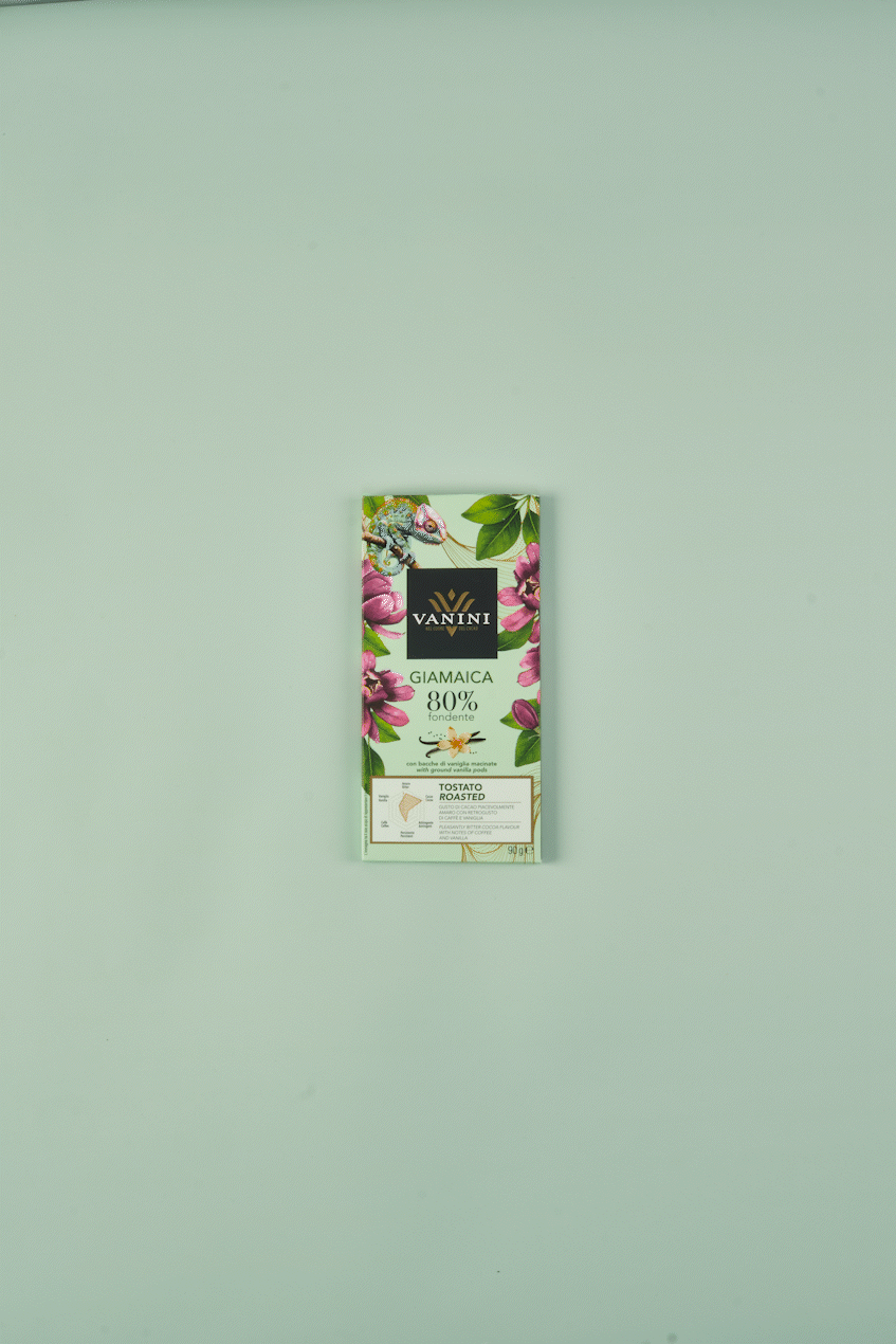 video di tavoletta di cioccolato che si scarta su sfondo neutro verde, con baccello di vaniglia e cacao
