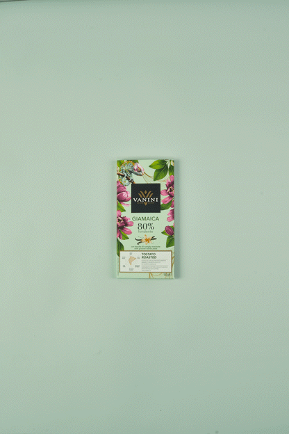 video di tavoletta di cioccolato che si scarta su sfondo neutro verde, con baccello di vaniglia e cacao