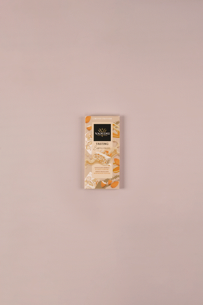 video tavoletta di cioccolato bianco al torrone si scarta e si divide, su sfondo neutro e decorato con torroni e mandorle
